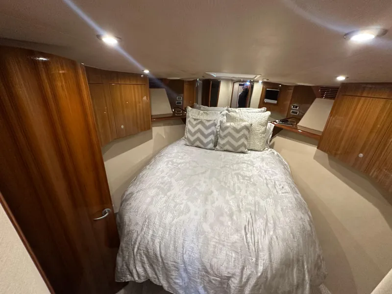 Slide: The Image of Luxurious bedroom interior of 2008 Viking 64 Enclosed Bridge yacht with wood paneling. - 22