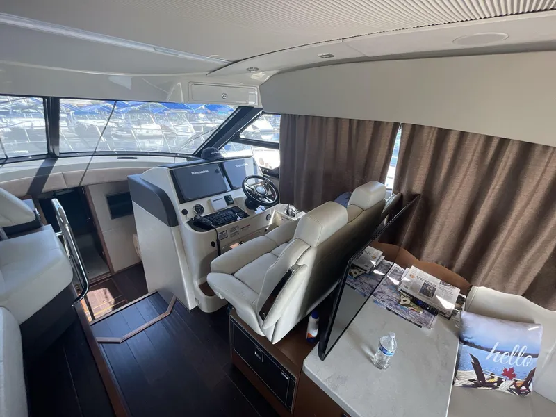 Slide: The Image of Interior of 2016 Sea Ray 470 Sundancer yacht with helm, seating, and table. - 12