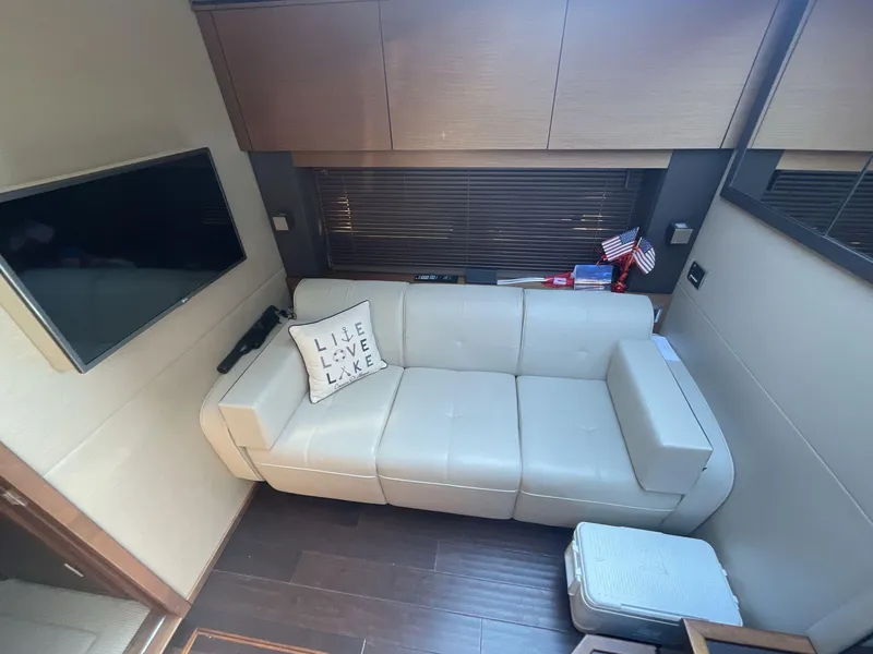 Slide: The Image of Interior of 2016 Sea Ray 470 Sundancer with white sofa and wall-mounted TV. - 16