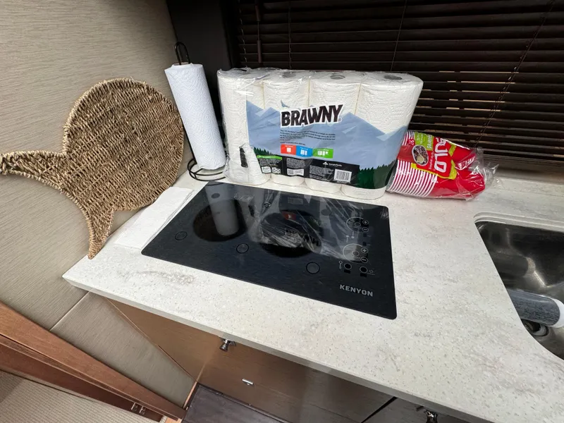 Slide: The Image of Compact kitchen area in a 2016 Sea Ray 470 Sundancer yacht with stove and supplies. - 18