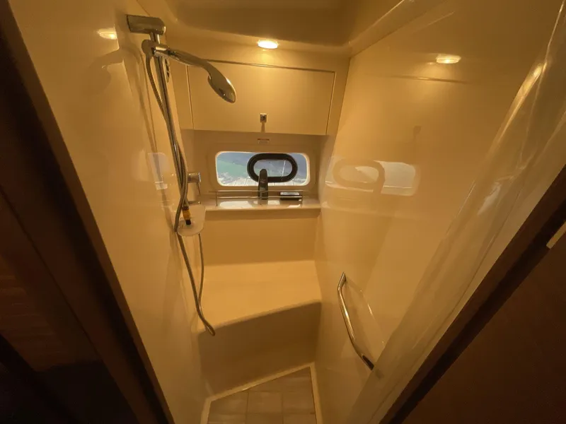 Slide: The Image of Shower area in 2016 Sea Ray 470 Sundancer yacht, featuring modern fixtures and window. - 22