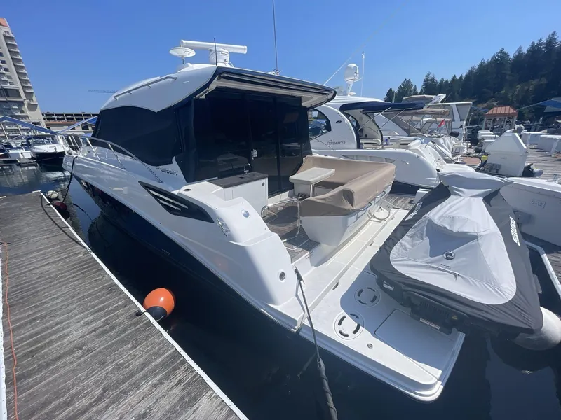 Slide: The Image of 2016 Sea Ray 470 Sundancer yacht docked with jet ski, sunny marina setting. - 5