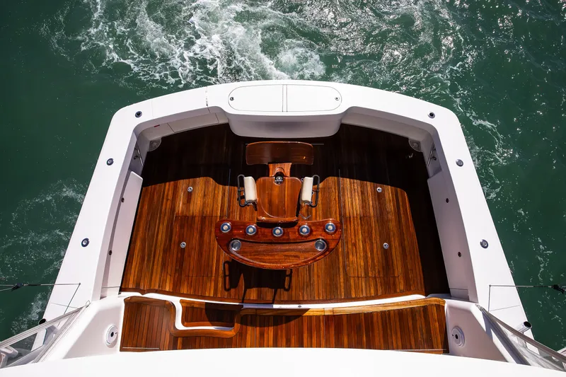 Slide: The Image of 2019 Viking 62 Convertible yacht with polished wooden deck and fishing chair. - 18
