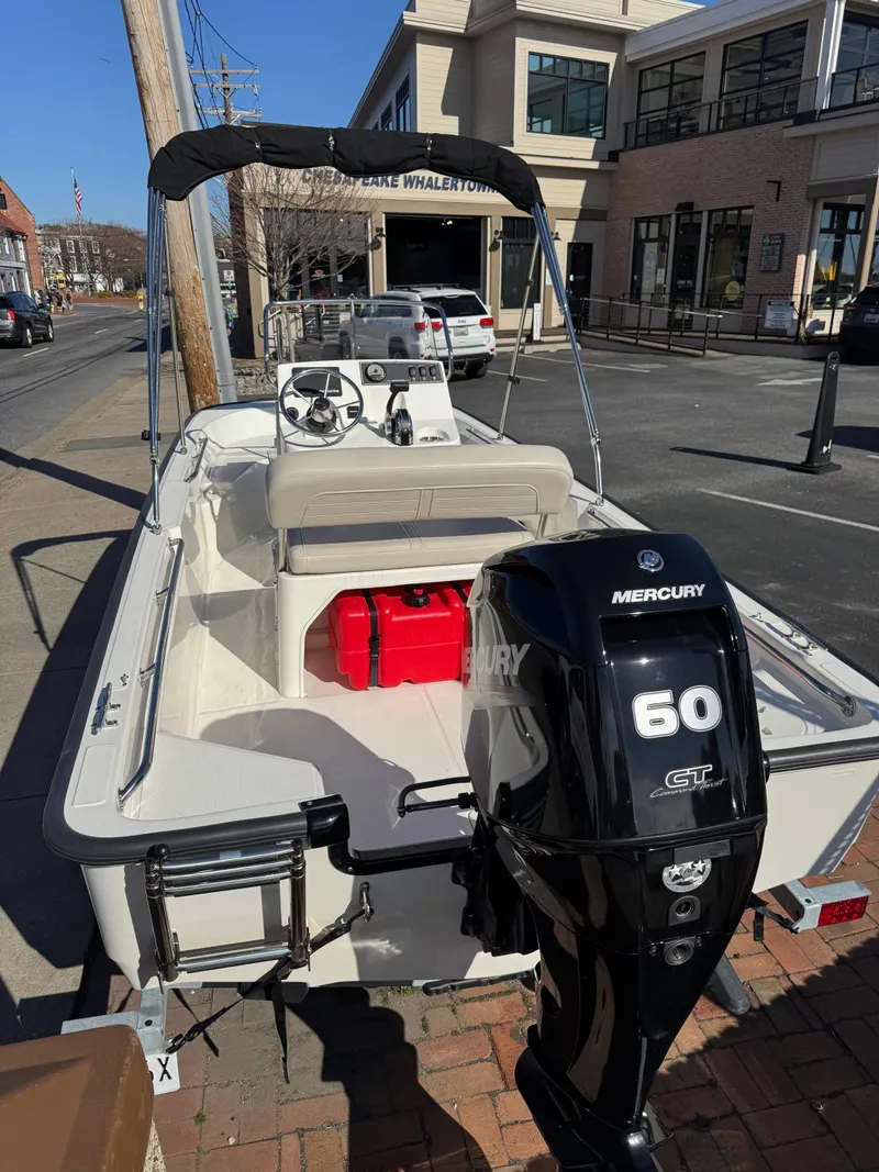 Slide: The Image of 2022 Boston Whaler 150 Montauk boat with Mercury 60 HP engine on urban street. - 2