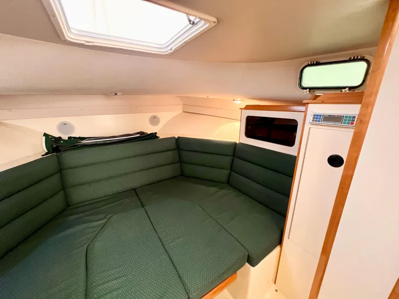 Slide: The Image of 2000 Albin 28 Tournament Express cabin with green cushioned seating and natural light. - 12