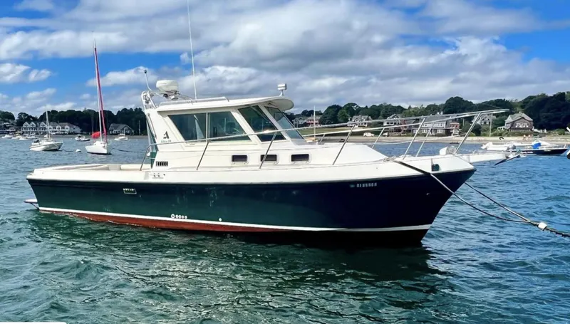 Slide: The Image of 2000 Albin 28 Tournament Express boat on water, clear sky, scenic background. - 3