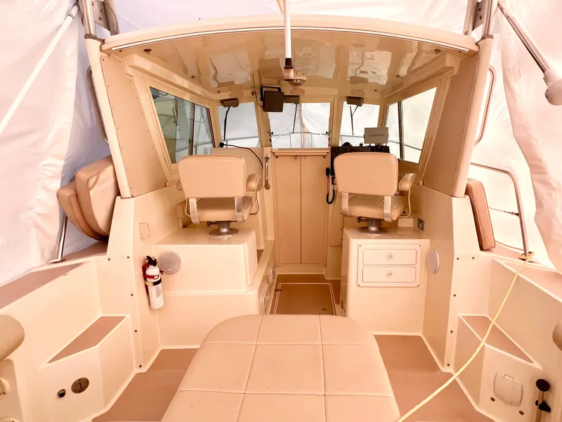 Slide: The Image of 2000 Albin 28 Tournament Express boat interior with beige seating and helm area. - 4