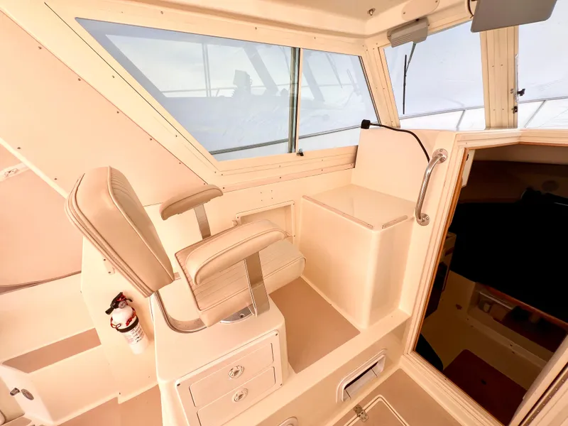 Slide: The Image of Interior of 2000 Albin 28 Tournament Express boat, featuring helm seat and cabin entrance. - 6