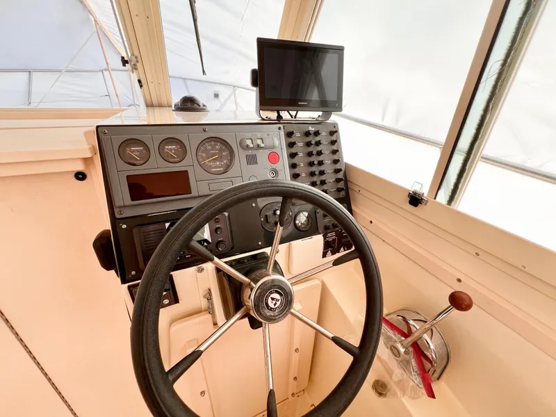 Slide: The Image of Helm of 2000 Albin 28 Tournament Express with steering wheel and navigation controls. - 9