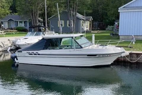 Slide: The Image of 1990 Thompson 240 Fisherman boat docked by lakeside homes. - 0