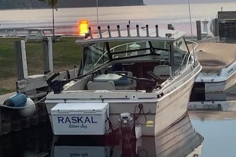 Slide: The Image of 1990 Thompson 240 Fisherman boat docked at sunset, named "Raskal." - 1