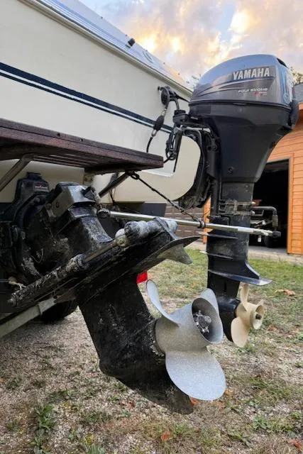 Slide: The Image of 1990 Thompson 240 Fisherman boat with Yamaha outboard motor, parked on grass. - 16