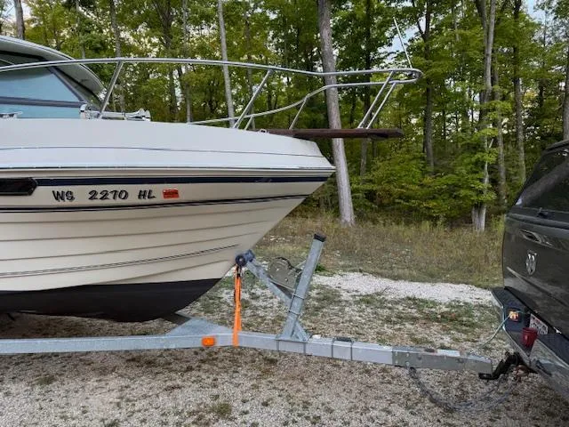 Slide: The Image of 1990 Thompson 240 Fisherman boat on trailer, parked in wooded area. - 2