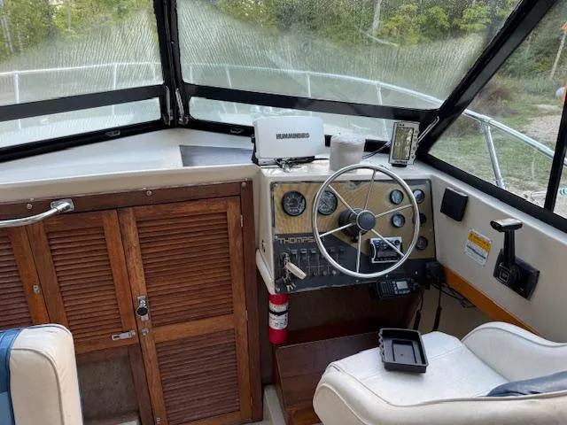 Slide: The Image of Interior of a 1990 Thompson 240 Fisherman boat with steering wheel and control panel. - 9