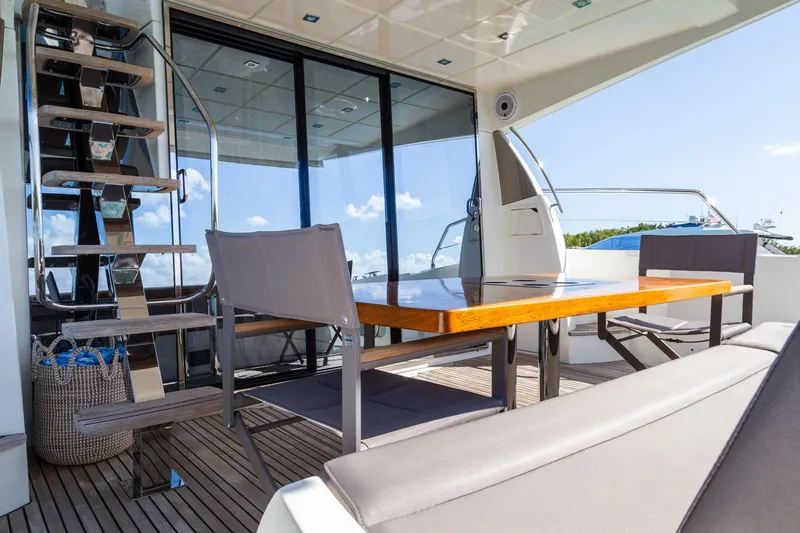 Slide: The Image of Prestige 560 Flybridge 2018 yacht deck with seating and table, featuring modern design. - 17