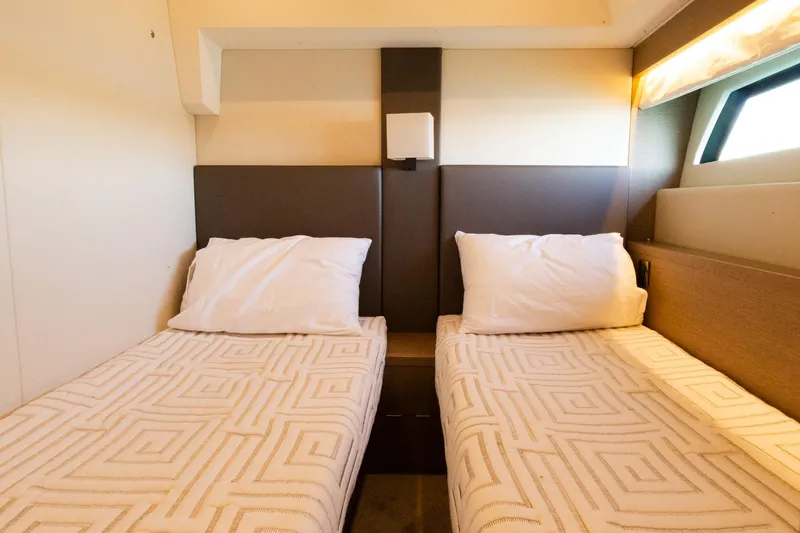 Slide: The Image of Twin beds in a 2018 Prestige 560 Flybridge yacht cabin, featuring modern design and cozy lighting. - 39