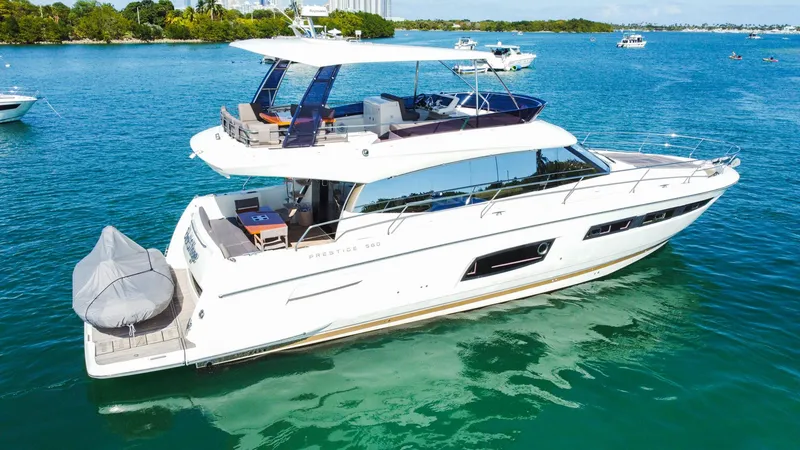 Slide: The Image of 2018 Prestige 560 Flybridge yacht cruising on clear blue water. - 4