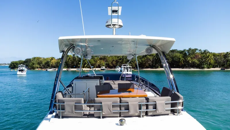 Slide: The Image of Prestige 560 Flybridge 2018 yacht on serene blue water with lush green shoreline. - 5