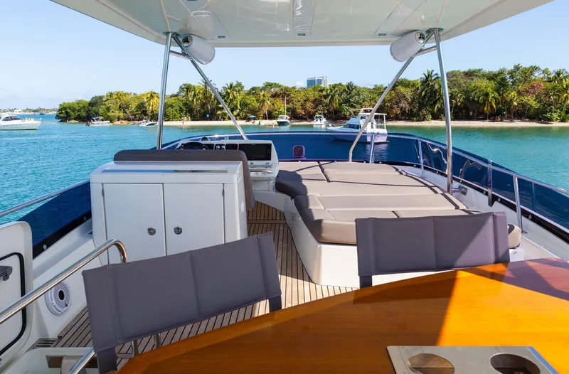 Slide: The Image of Prestige 560 Flybridge 2018 yacht with spacious deck and scenic waterfront view. - 9