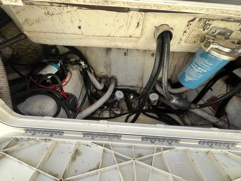 Slide: The Image of Engine compartment of a 2019 Key West 244 Center Console boat, showing hoses and components. - 11