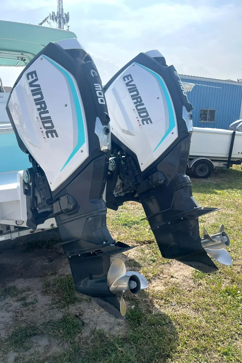 Slide: The Image of Twin Evinrude outboard motors on a 1966 Bertram 31 boat, parked on grass. - 19