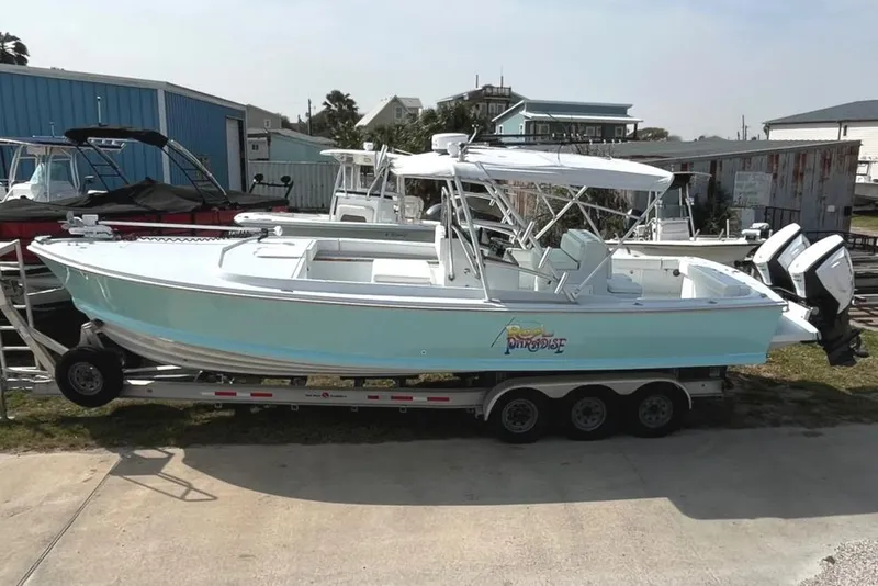 Slide: The Image of 1966 Bertram 31 boat on trailer, light blue hull, parked outdoors. - 2