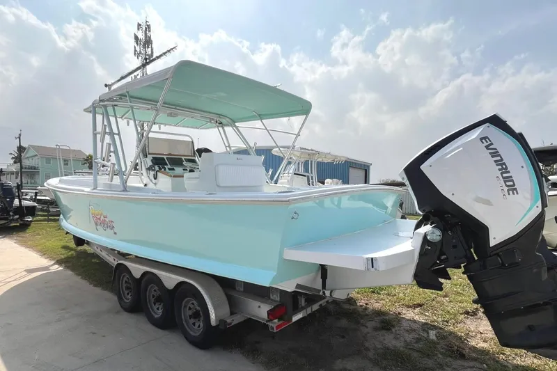 Slide: The Image of 1966 Bertram 31 boat with Evinrude outboard motor on a trailer, light blue color. - 4
