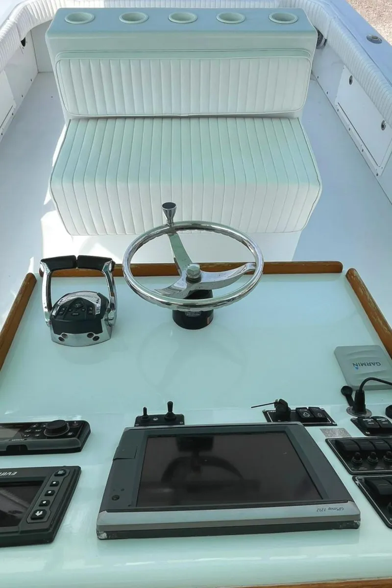 Slide: The Image of 1966 Bertram 31 boat helm with steering wheel and navigation controls. - 9