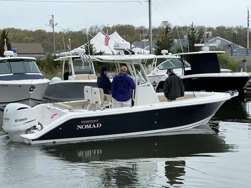 Slide: The Image of 2021 Pursuit C 238 Center Console boat on water with three people onboard. - 0