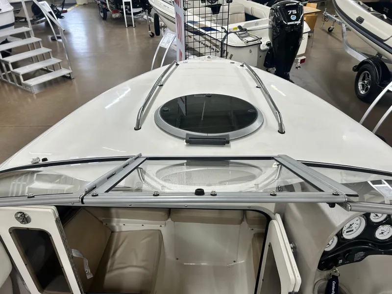 Slide: The Image of 2006 Stingray 205 Cuddy M/C boat interior with open hatch and dashboard view. - 15