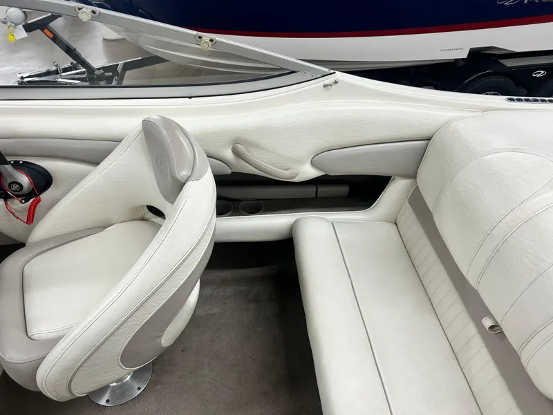 Slide: The Image of Interior of a 2006 Stingray 205 Cuddy M/C boat with white seating and steering wheel. - 16