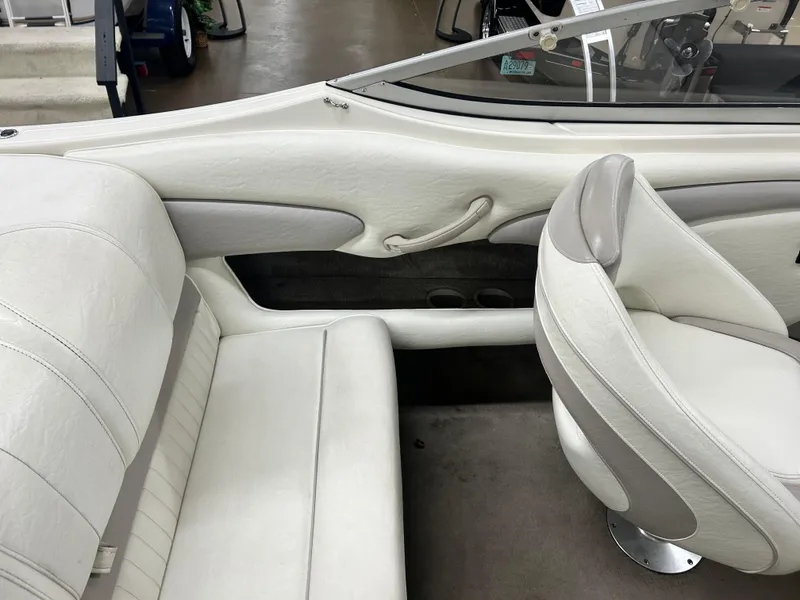 Slide: The Image of 2006 Stingray 205 Cuddy M/C boat interior with white seating and steering area. - 17