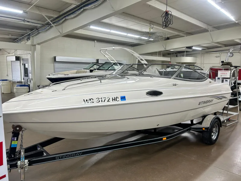Slide: The Image of 2006 Stingray 205 Cuddy M/C boat displayed indoors on a trailer. - 2
