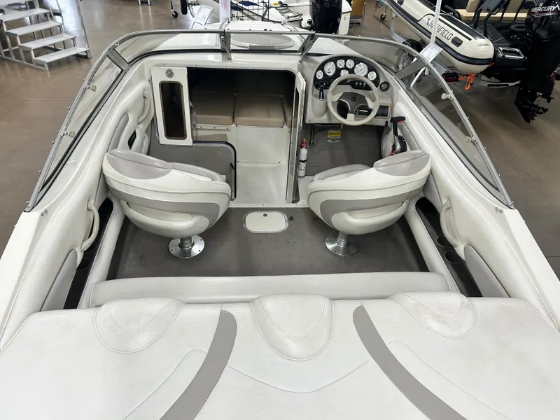Slide: The Image of 2006 Stingray 205 Cuddy M/C boat interior with white seating and dashboard controls. - 5
