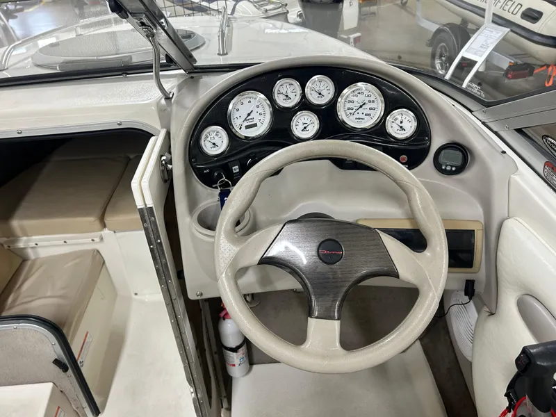 Slide: The Image of 2006 Stingray 205 Cuddy M/C boat interior with steering wheel and dashboard gauges. - 7