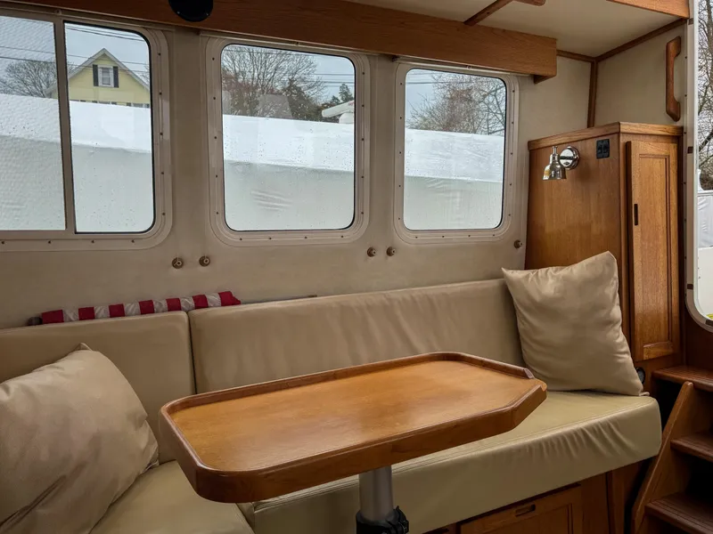 Slide: The Image of Interior of 2006 Nordic Tug 32' Plus with cozy seating and wooden table. - 10