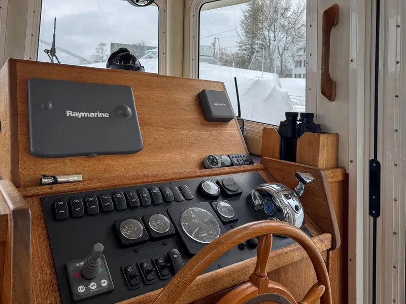 Slide: The Image of 2006 Nordic Tug 32' Plus helm with Raymarine navigation system and wooden steering wheel. - 11