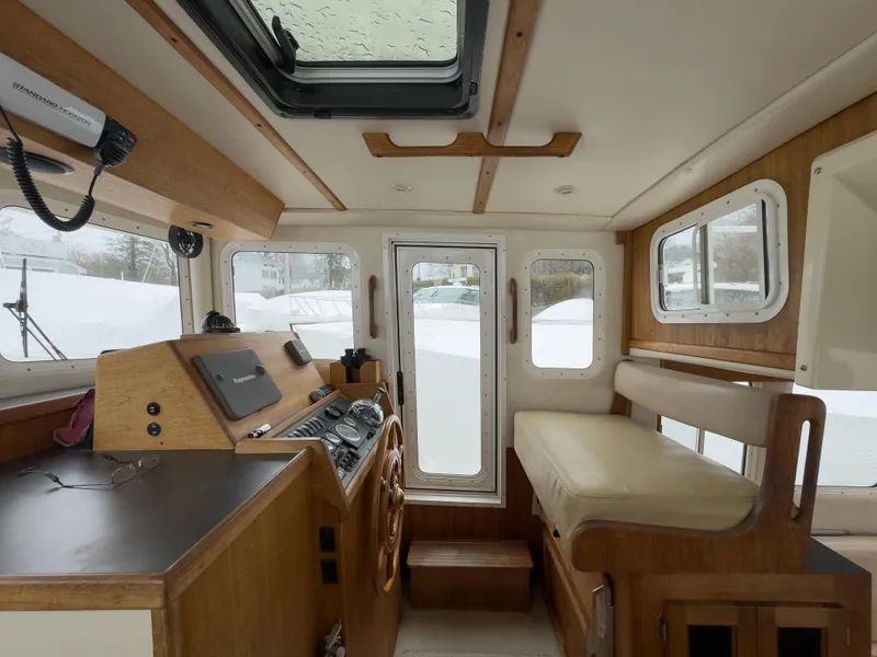 Slide: The Image of Interior of a 2006 Nordic Tug 32' Plus, featuring helm and seating area. - 15