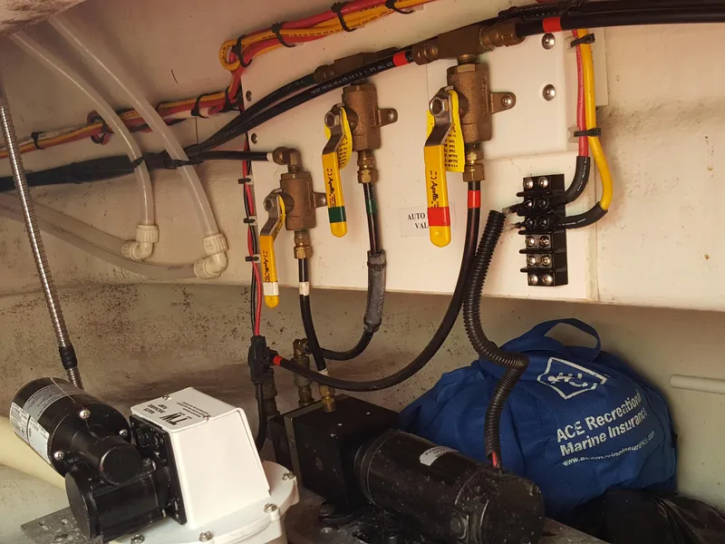 Slide: The Image of Engine room of a 2006 Nordic Tug 32' Plus with visible wiring and valves. - 19