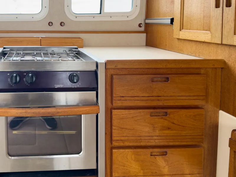 Slide: The Image of 2006 Nordic Tug 32' Plus kitchen with stove and wooden cabinetry. - 3
