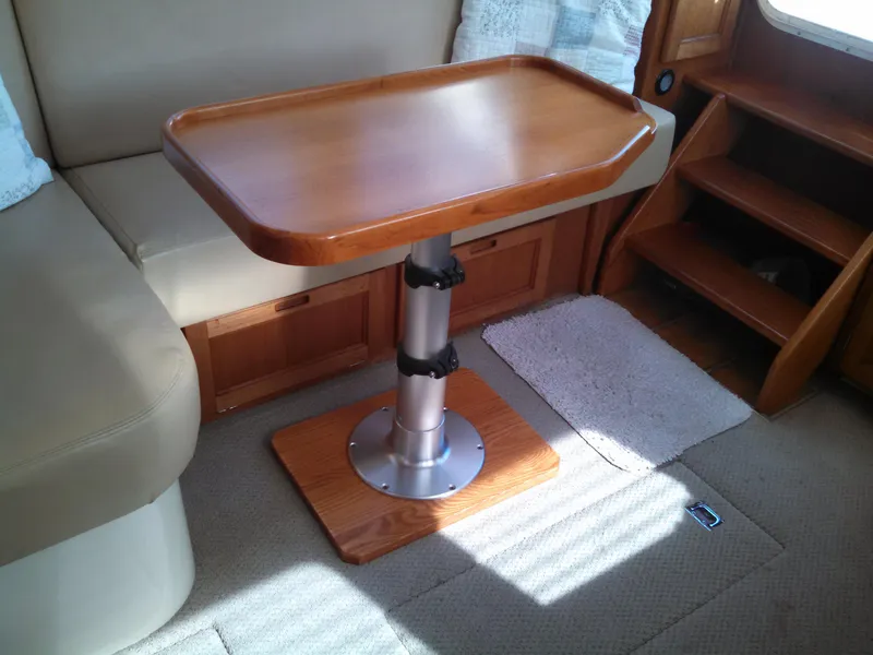 Slide: The Image of Interior of a 2006 Nordic Tug 32' Plus, featuring a wooden table and seating area. - 6