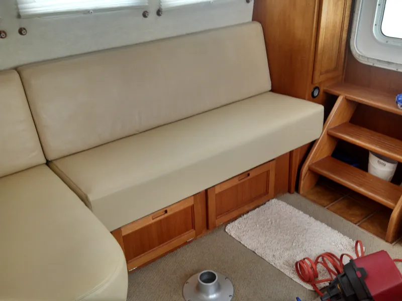 Slide: The Image of Interior of a 2006 Nordic Tug 32' Plus with beige seating and wooden storage. - 8