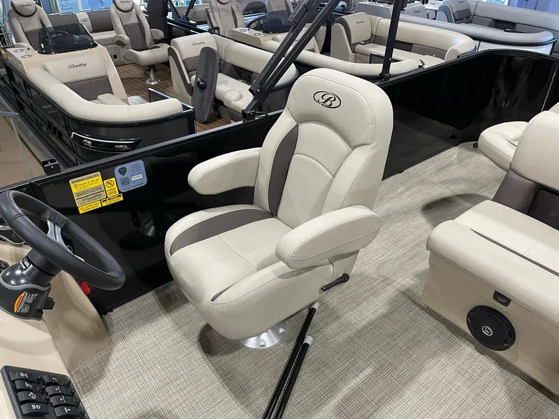 Slide: The Image of 2025 Bentley Pontoons 223 Fish interior with beige captain's chair and steering wheel. - 10