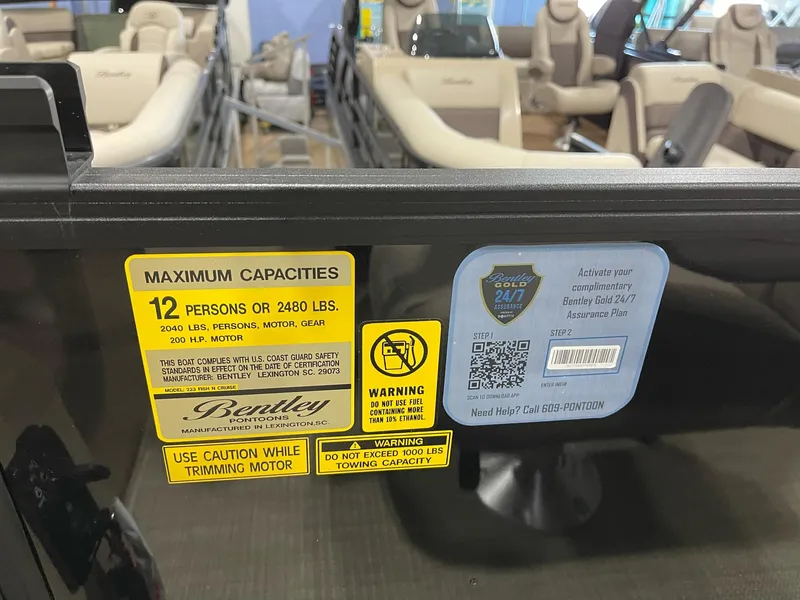 Slide: The Image of 2025 Bentley Pontoons 223 Fish capacity label, seating for 12, safety warnings visible. - 15
