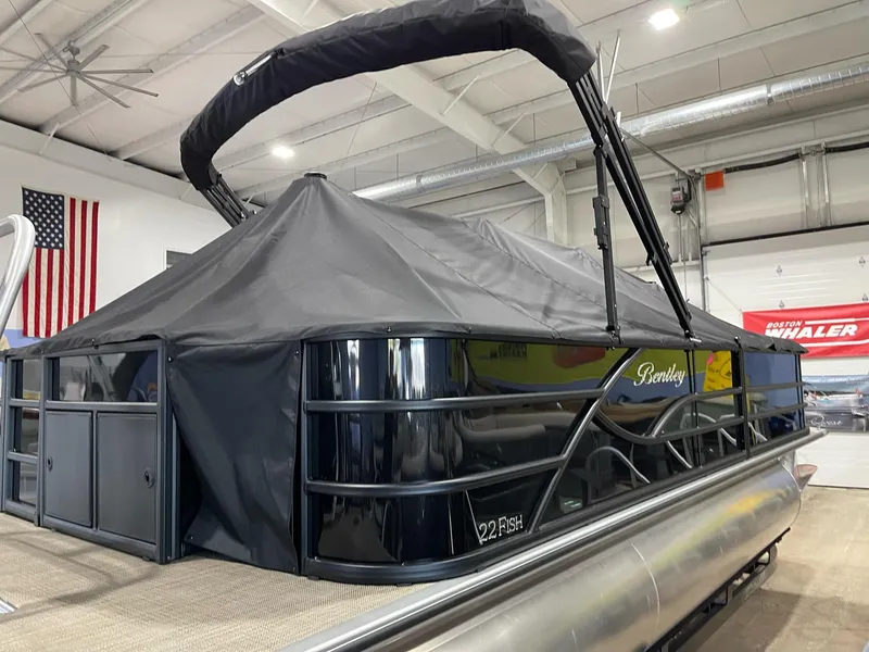 Slide: The Image of 2025 Bentley Pontoons 223 Fish pontoon boat with cover in a showroom. - 2