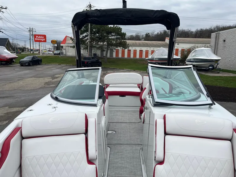 Slide: The Image of 2023 Crownline 260 SS boat with white and red interior, parked outdoors. - 4