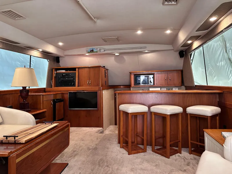 Slide: The Image of Interior of 1990 Ocean Yachts 48 Super Sport with white leather seating and wooden accents. - 20