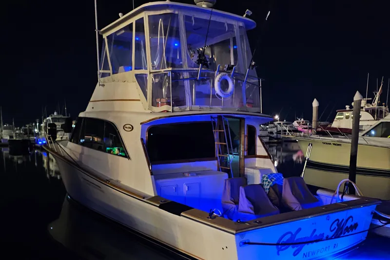 Slide: The Image of 1990 Ocean Yachts 48 Super Sport docked at night with blue underwater lights. - 5