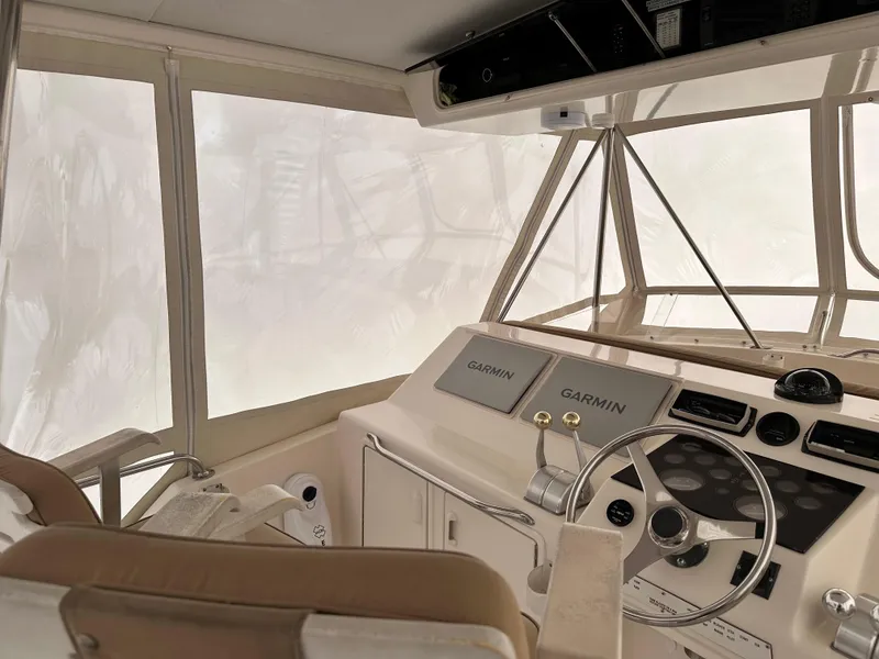 Slide: The Image of 1990 Ocean Yachts 48 Super Sport helm with steering wheel and control panels. - 14