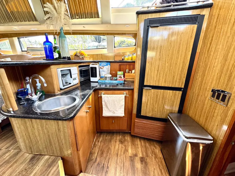 Slide: The Image of Interior of 2001 Carver 396 Motor Yacht kitchen with wood cabinetry and modern appliances. - 15